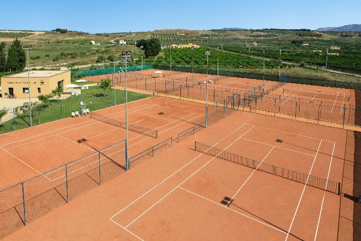 Clay tennis courts at Verdura Resort Tennis Club surrounded by Sicilian countryside.